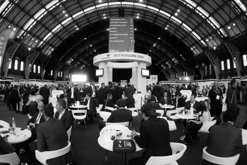 Stands, chairs, tables, people and televisions at Soccerex week